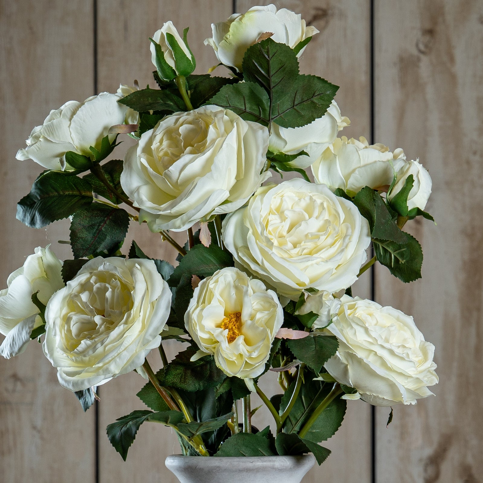Bouquet of white roses in a vase against a wooden background