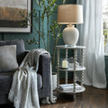 Living room with gray sofa, white lamp, and decorative items on a wooden floor.