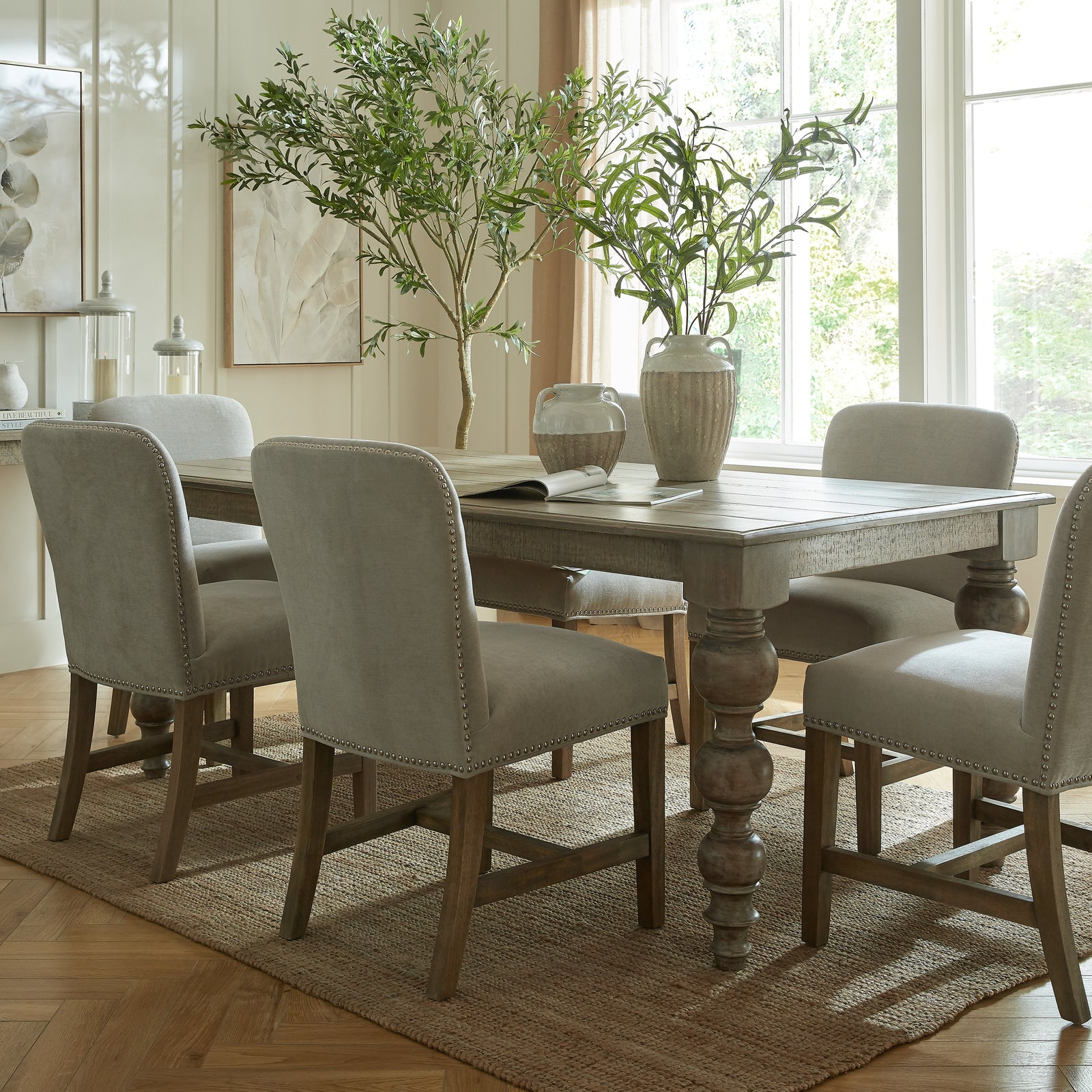 Dining room with a wooden table and chairs near large windows.