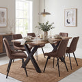 Dining room with a wooden table and brown chairs on a beige rug.