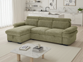 Green sectional sofa in a living room with a coffee table and books.