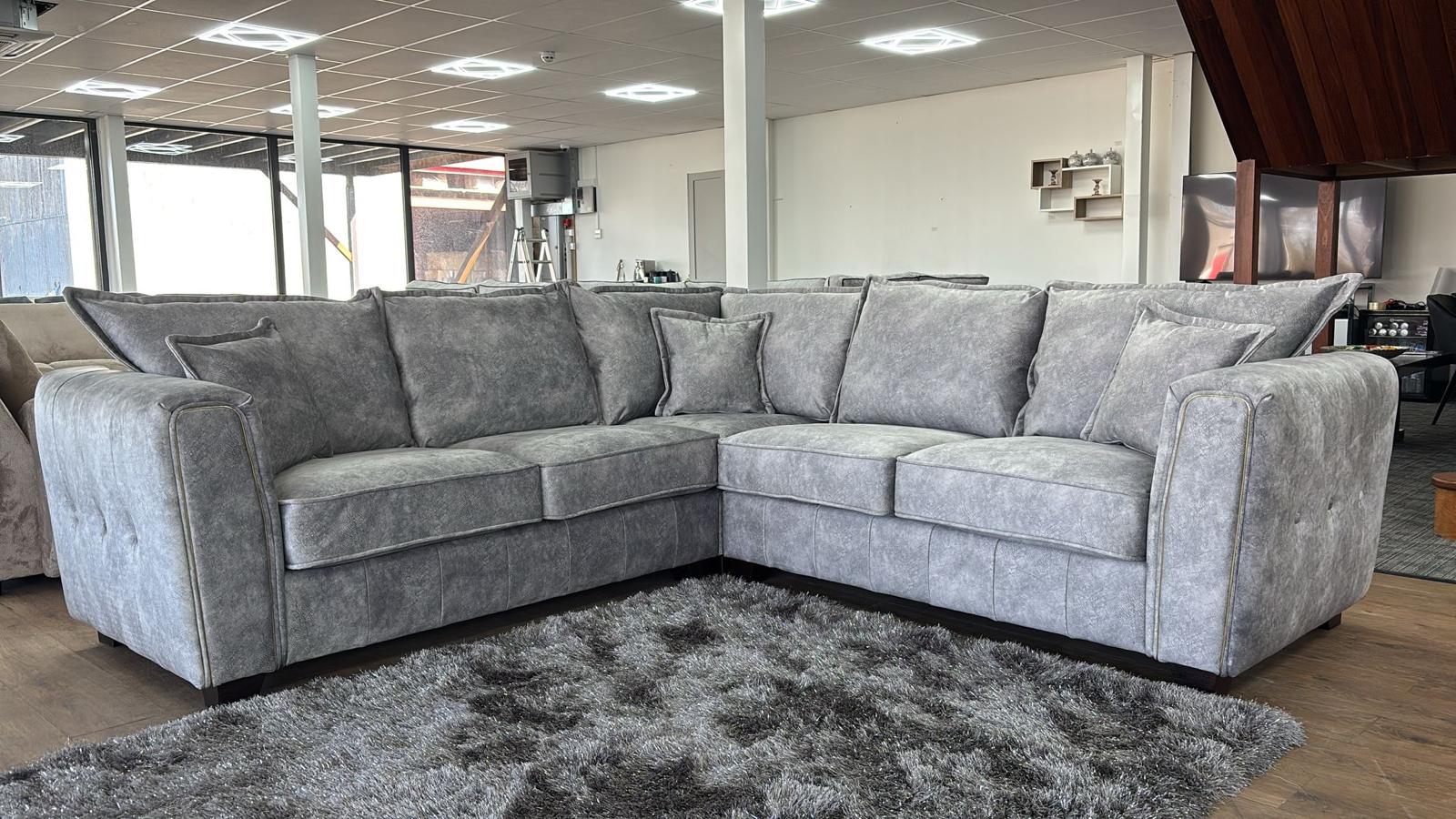 Gray sectional sofa in a room with large windows and modern decor.