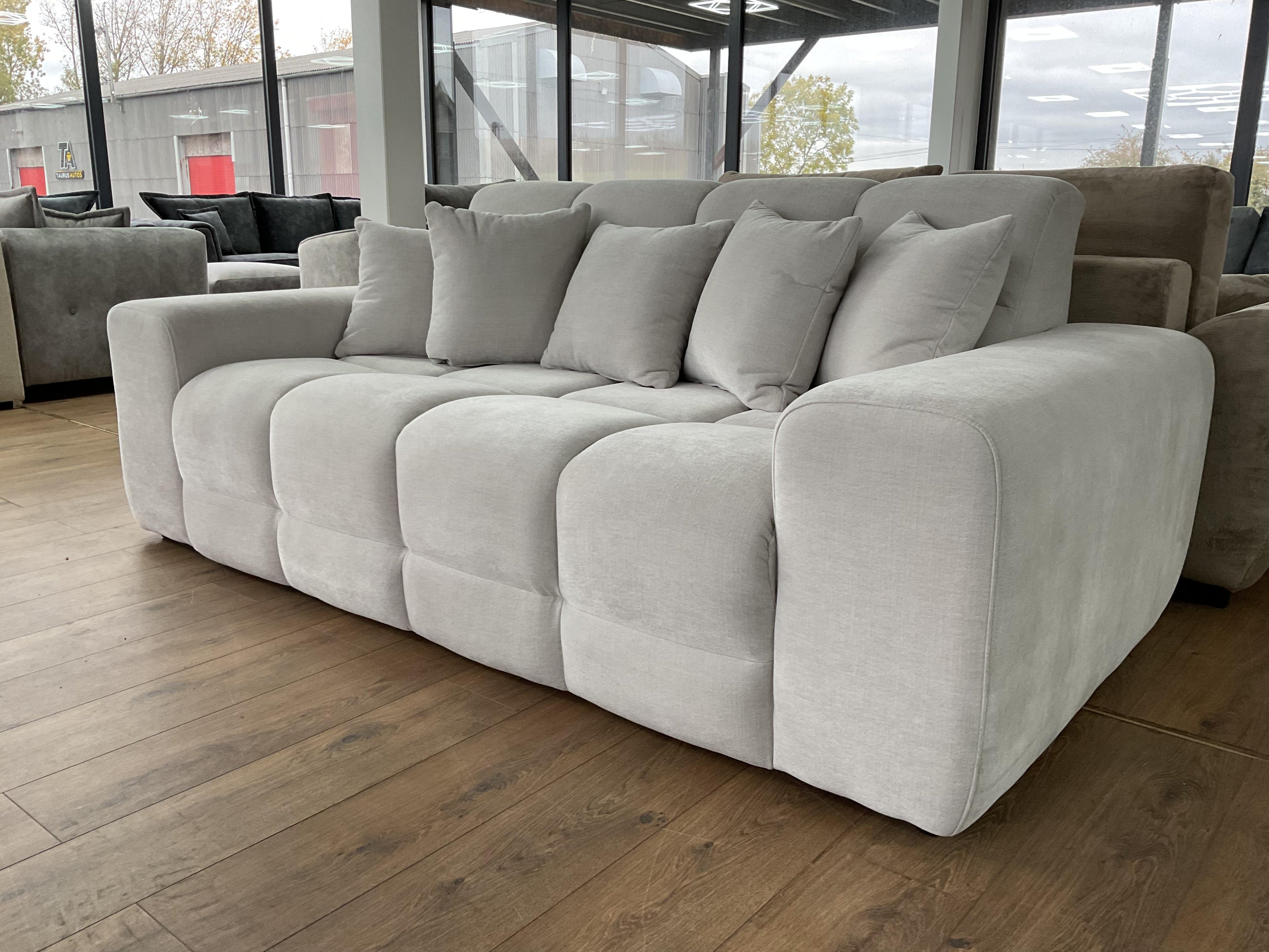 Large gray sectional sofa in a room with large windows.
