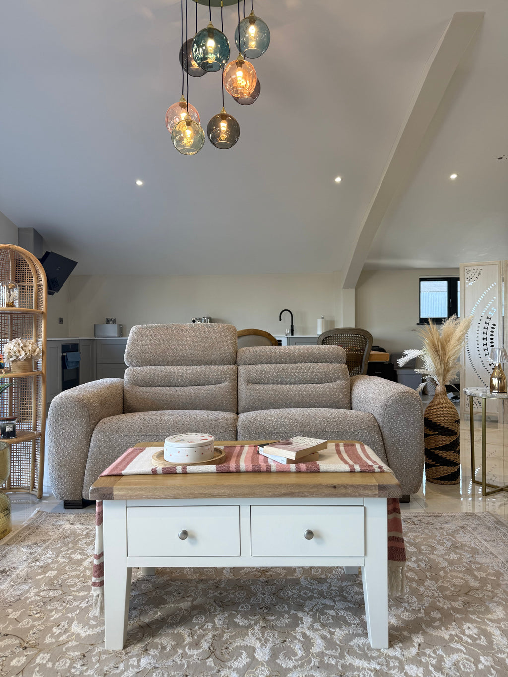 Living room with beige sofa, wooden coffee table, and modern pendant lights.