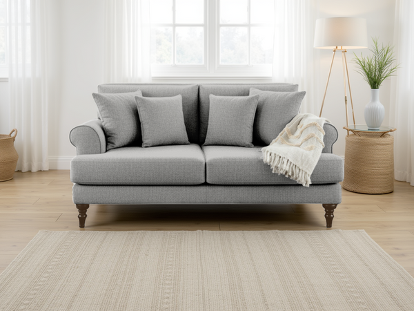 Gray sofa with cushions and a blanket in a bright living room.