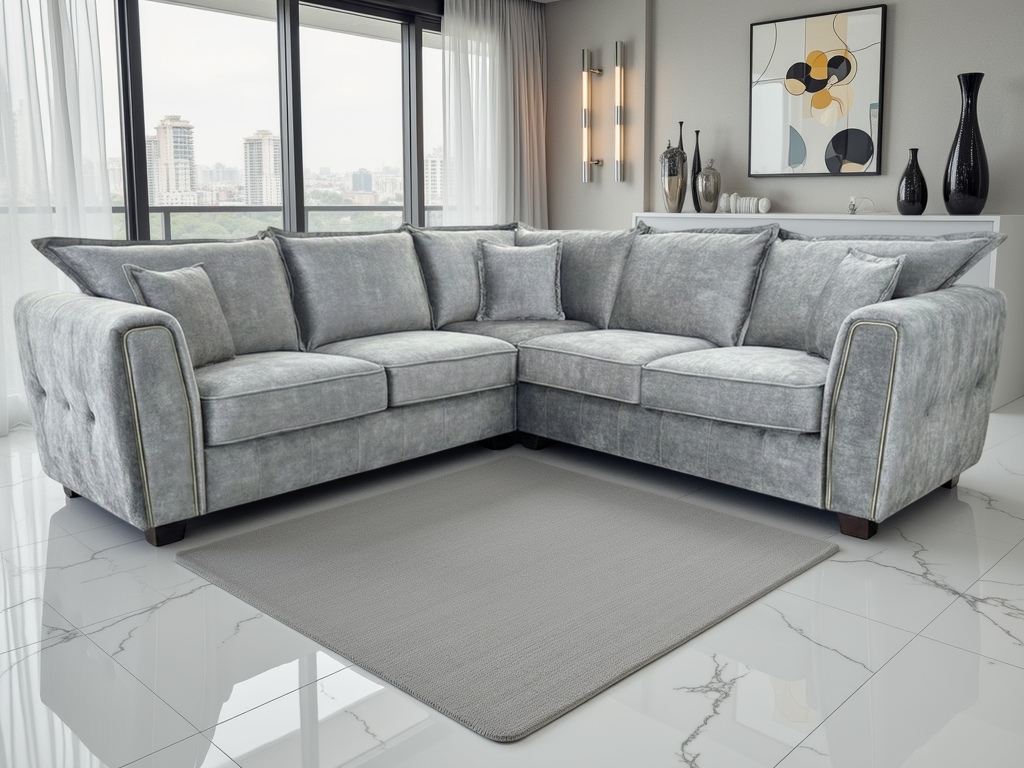 Gray sectional sofa in a modern living room with large windows and decorative items.